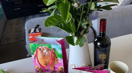 Yeu’s Sisterlocs in Kempton Park, Gauteng, ZA showcases a stylish table with flowers, wine, and a playful gift bag.