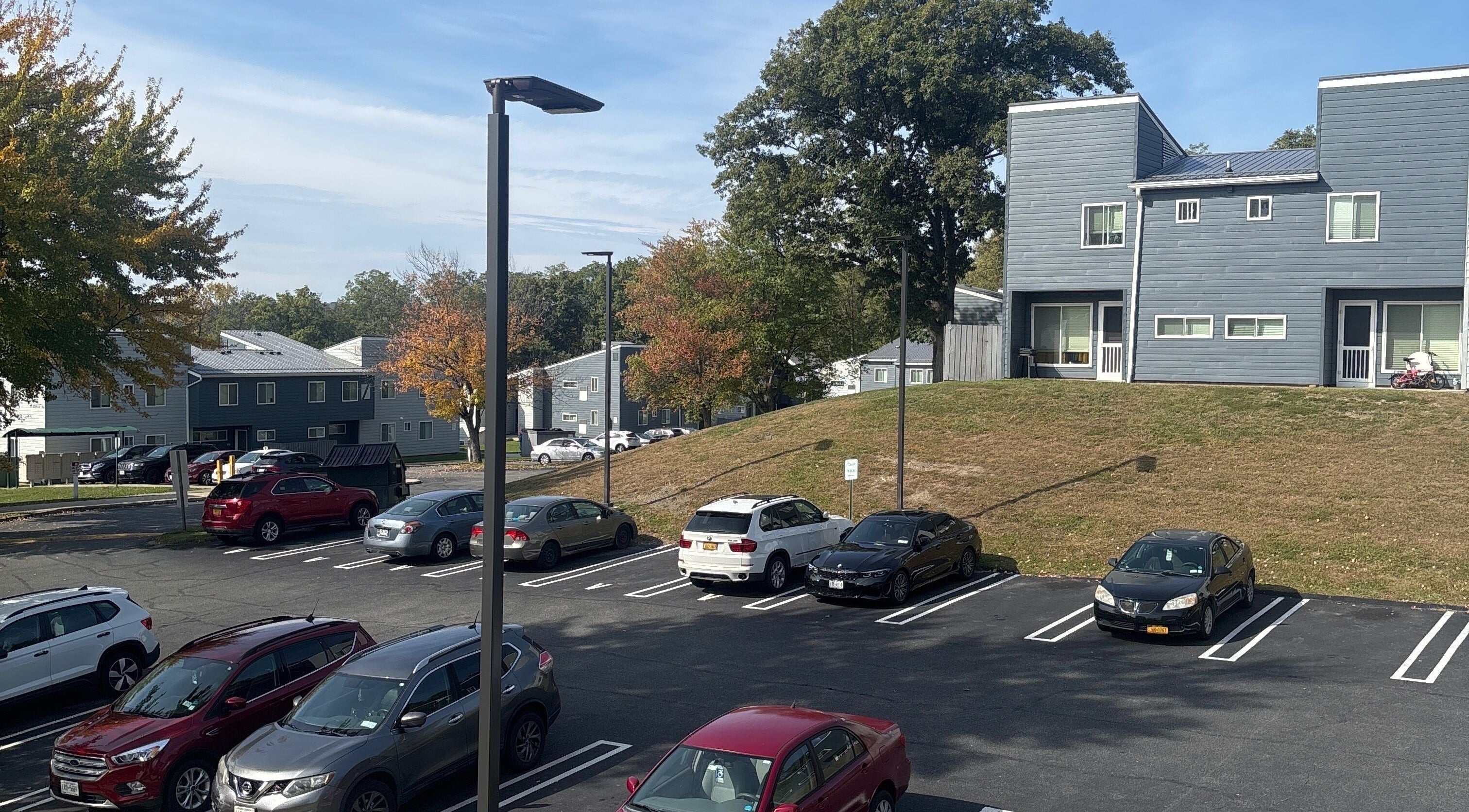 Scenic parking view at Leschae Braids 2.0, Beacon, New York, showcasing modern architecture and autumn trees.