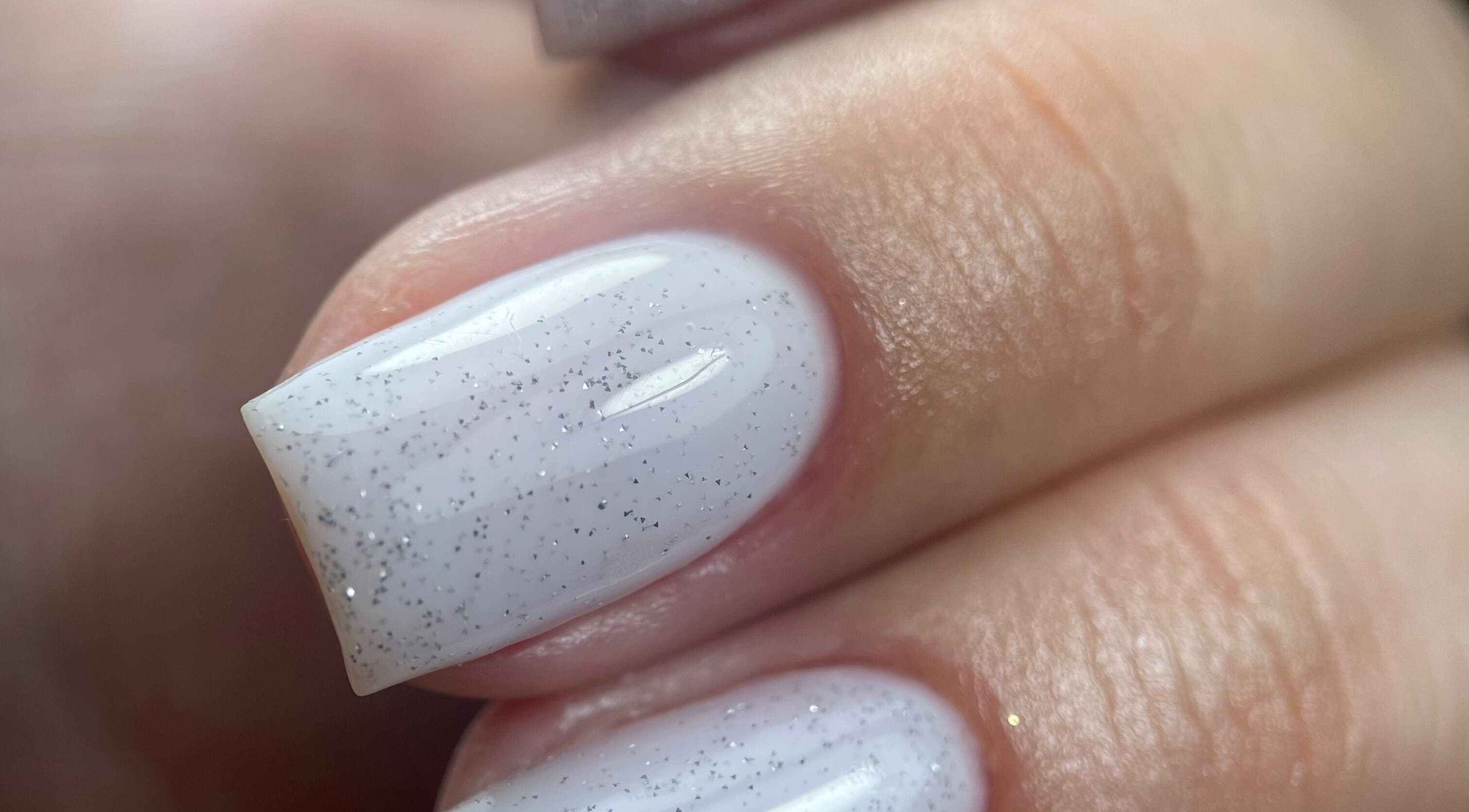 Des ongles élégants avec vernis blanc pailleté à cloe.manucurist, Andernos-les-Bains, Nouvelle-Aquitaine, FR.