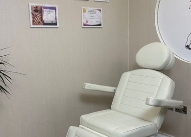 Elegant treatment chair in D&M Nails Salon, Bletchley, England, GB, with nearby plant and certificates on wall.