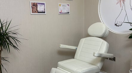Elegant treatment chair in D&M Nails Salon, Bletchley, England, GB, with nearby plant and certificates on wall.