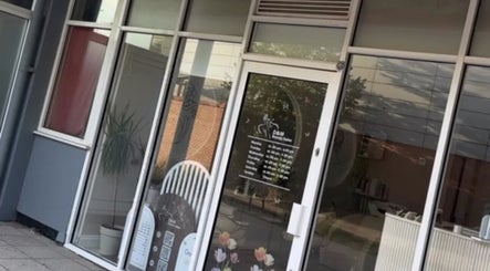 Entrance of D&M Nails Salon in Bletchley, England, GB with glass doors and stylish signage.