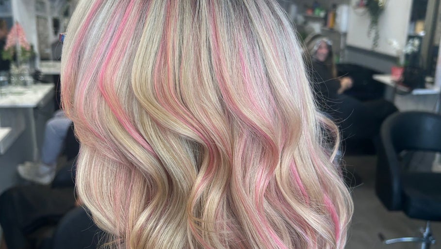 Vibrant pink highlights in blonde waves at Vikki’s Hair, Appledore, England, GB salon.
