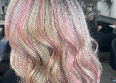 Vibrant pink highlights in blonde waves at Vikki’s Hair, Appledore, England, GB salon.