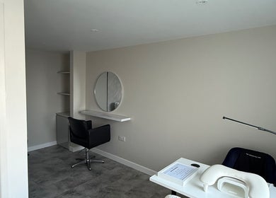 Modern beauty station at Honey Luxe Nails, Gosport, England, GB, featuring a sleek chair and round mirror.