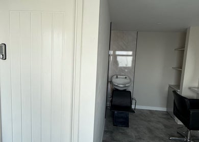 Modern salon corner at Honey Luxe Nails, Gosport, England, GB with a styling chair and round mirror.