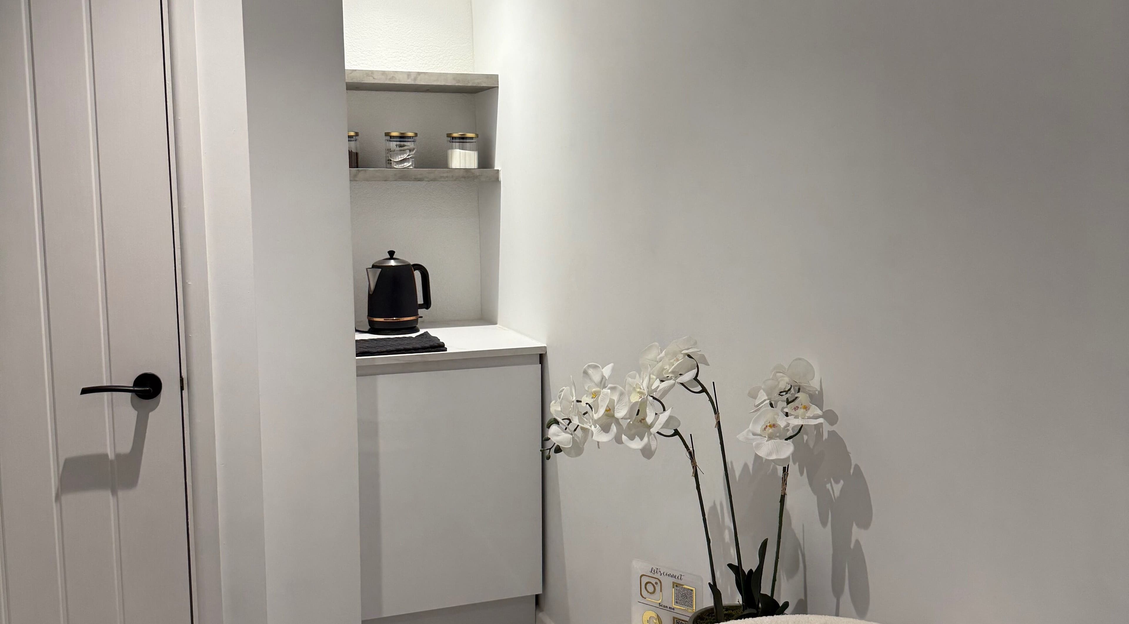 Stylish tea corner with orchids at Honey Luxe Nails in Gosport, England, GB.