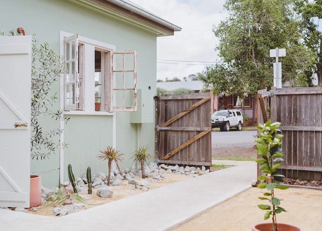 Charming outdoor entrance of Baby Jane hair in Bellingen, New South Wales, AU, featuring rustic doors and greenery.