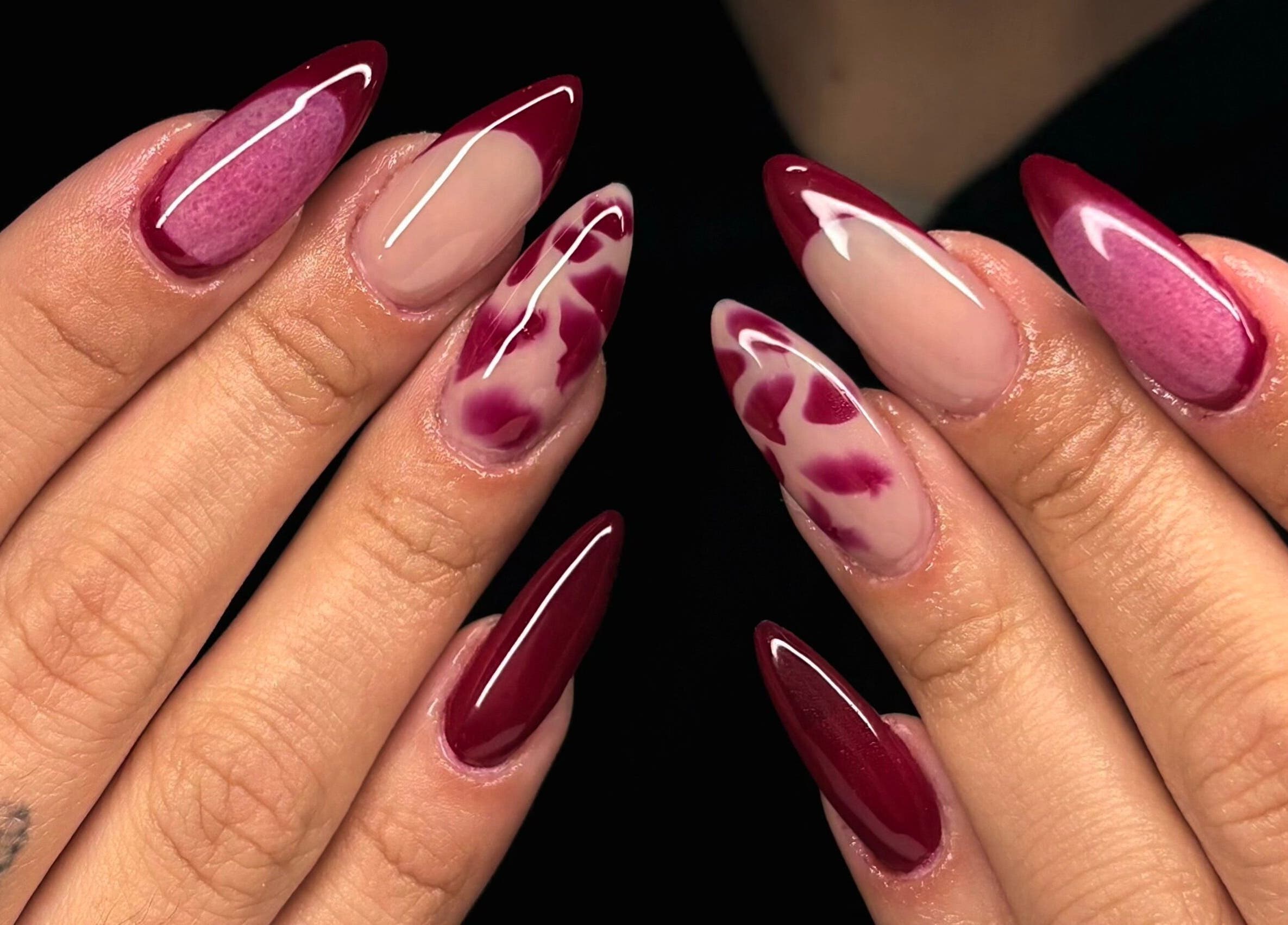 Elegant crimson nail art from Maison Ébène, Montréal, Québec, CA, showcasing intricate design.