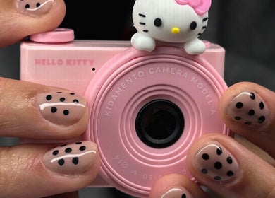 Polka dot manicure at Maison Ébène, Montréal, Québec, CA, holding cute pink camera.