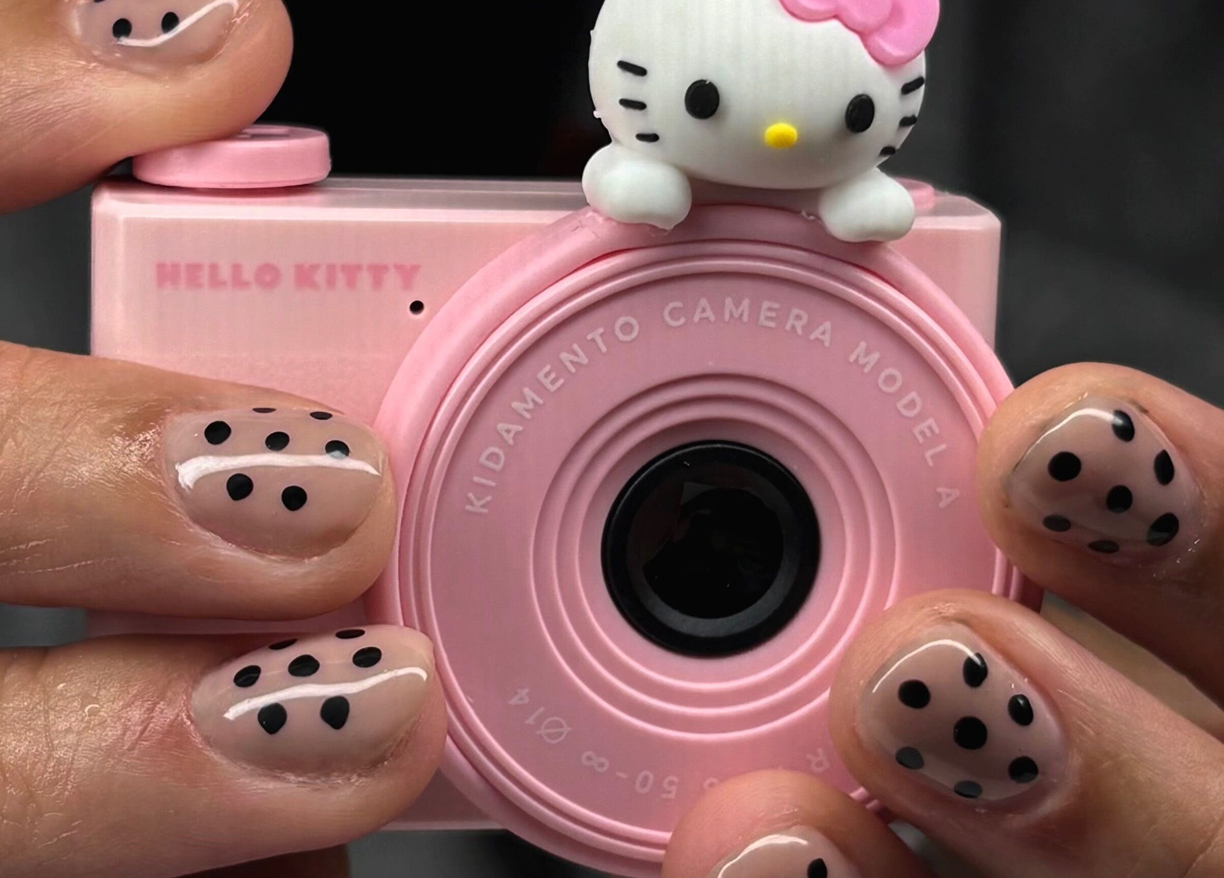 Polka dot manicure at Maison Ébène, Montréal, Québec, CA, holding cute pink camera.