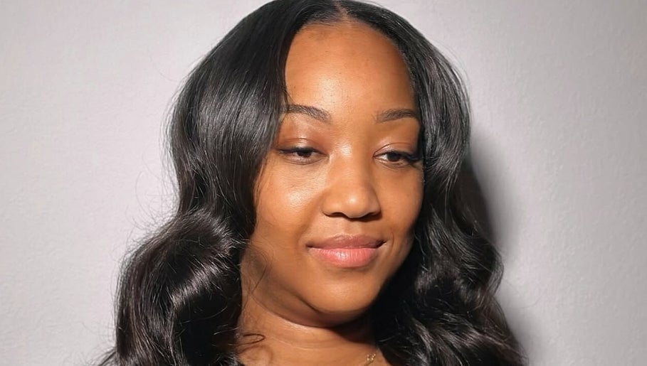 Smiling woman with styled hair at Quori B. Aesthetics, Louisville, Kentucky, US.