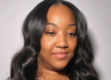 Smiling woman with styled hair at Quori B. Aesthetics, Louisville, Kentucky, US.