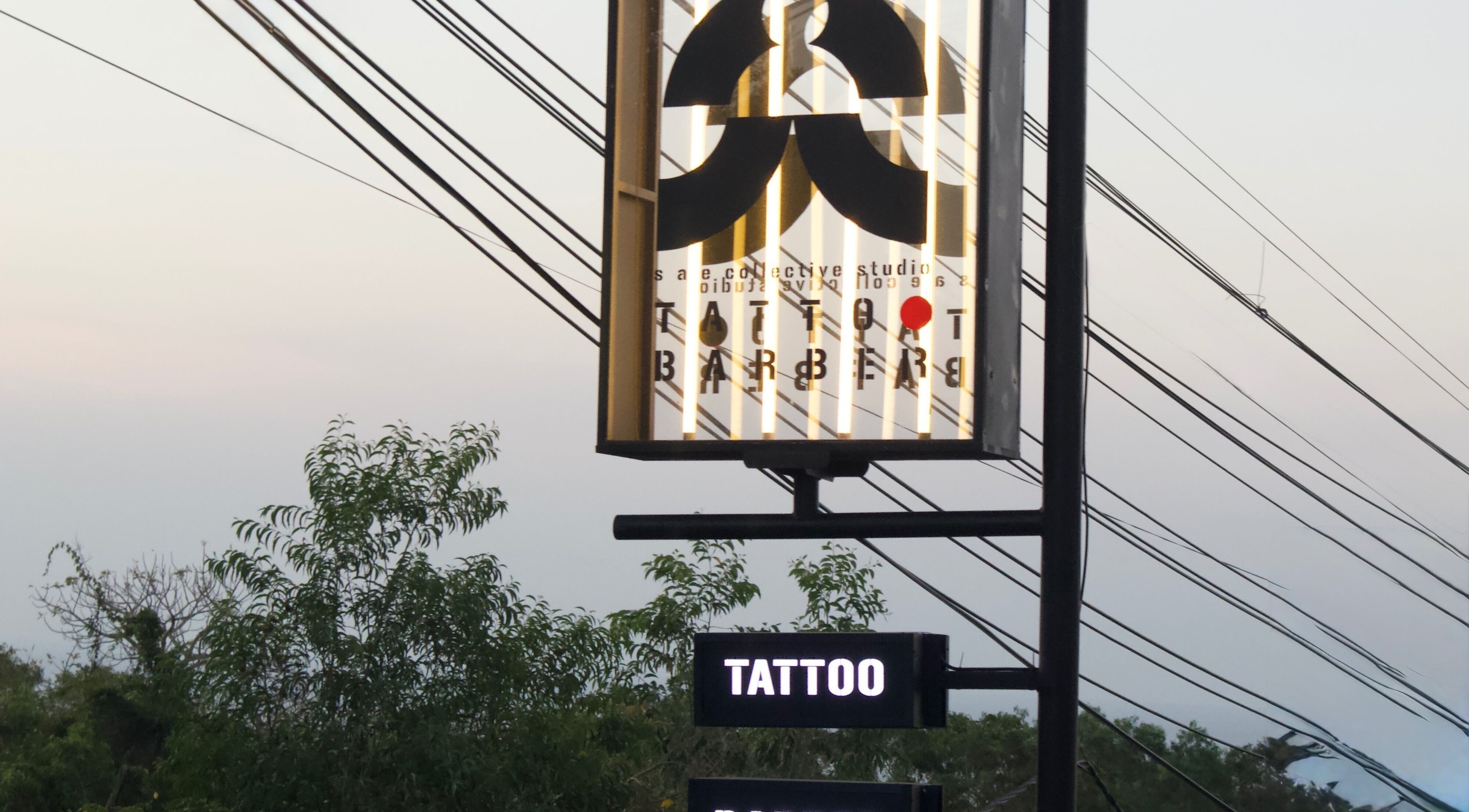 Illuminated Sae Collective Barber sign with trees in Bali, Bali, ID during dusk.