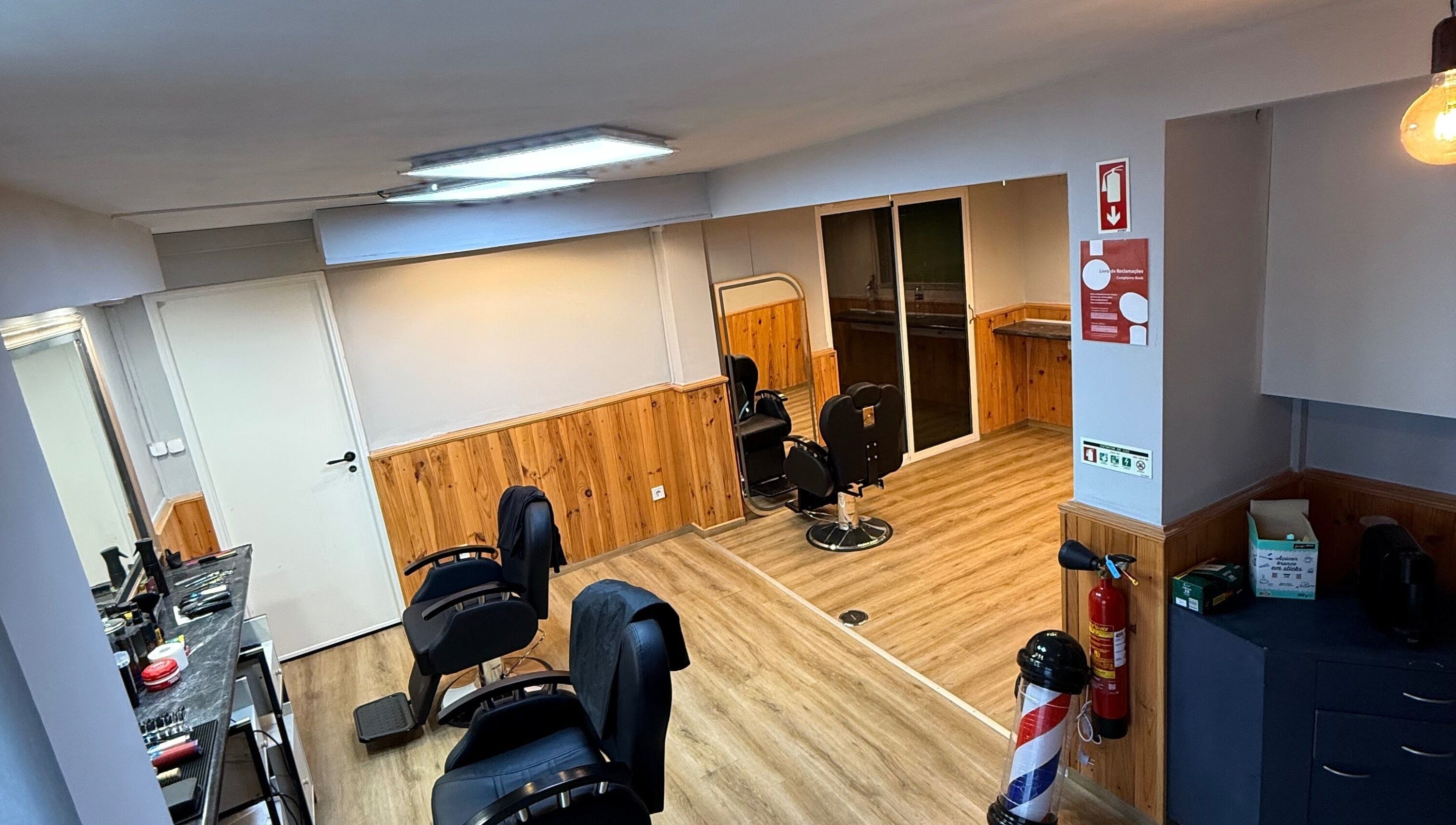 Interior moderno da Connect cut Barbers, Lisboa, PT, com cadeiras e espelhos elegantes.