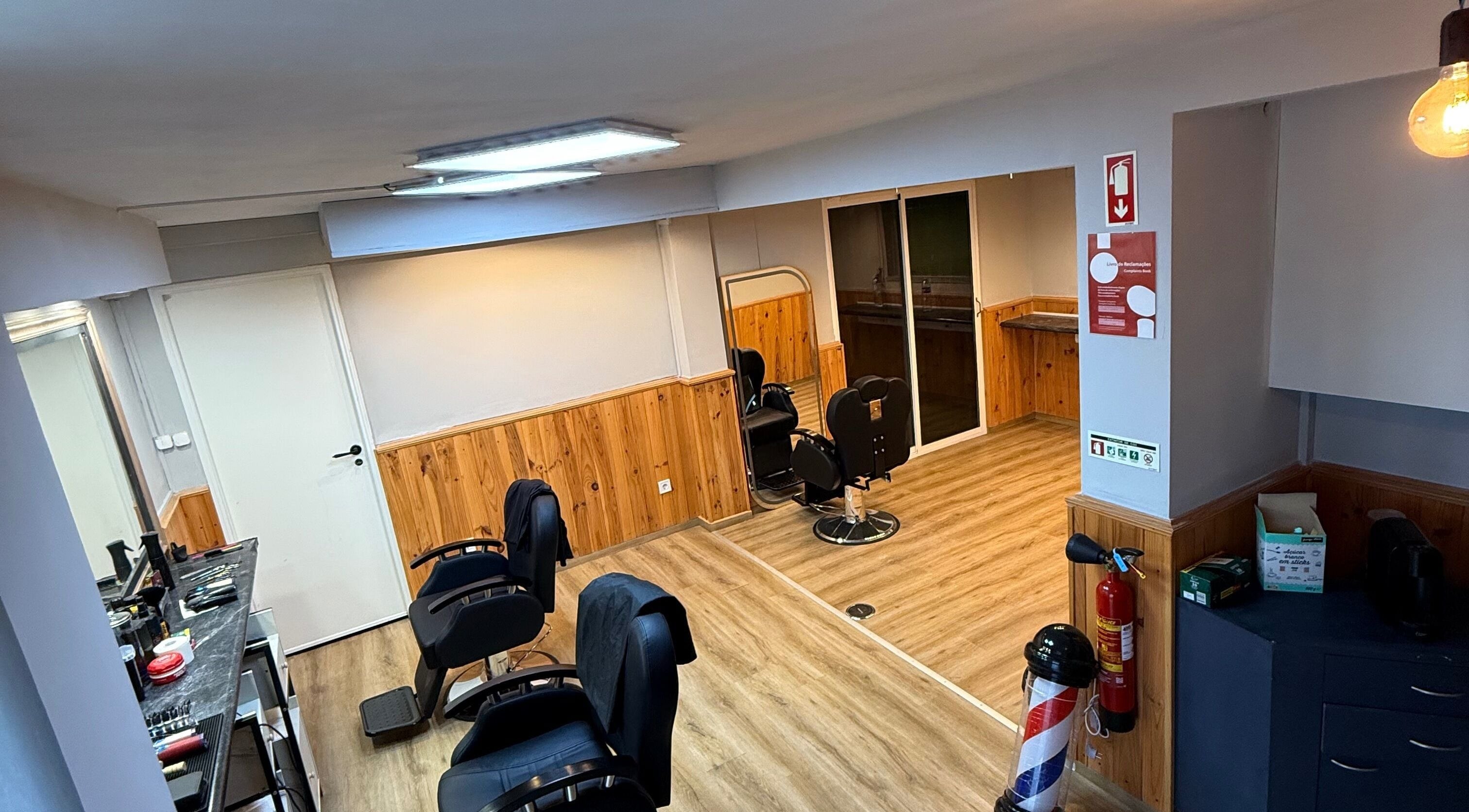 Interior moderno da Connect cut Barbers, Lisboa, PT, com cadeiras e espelhos elegantes.