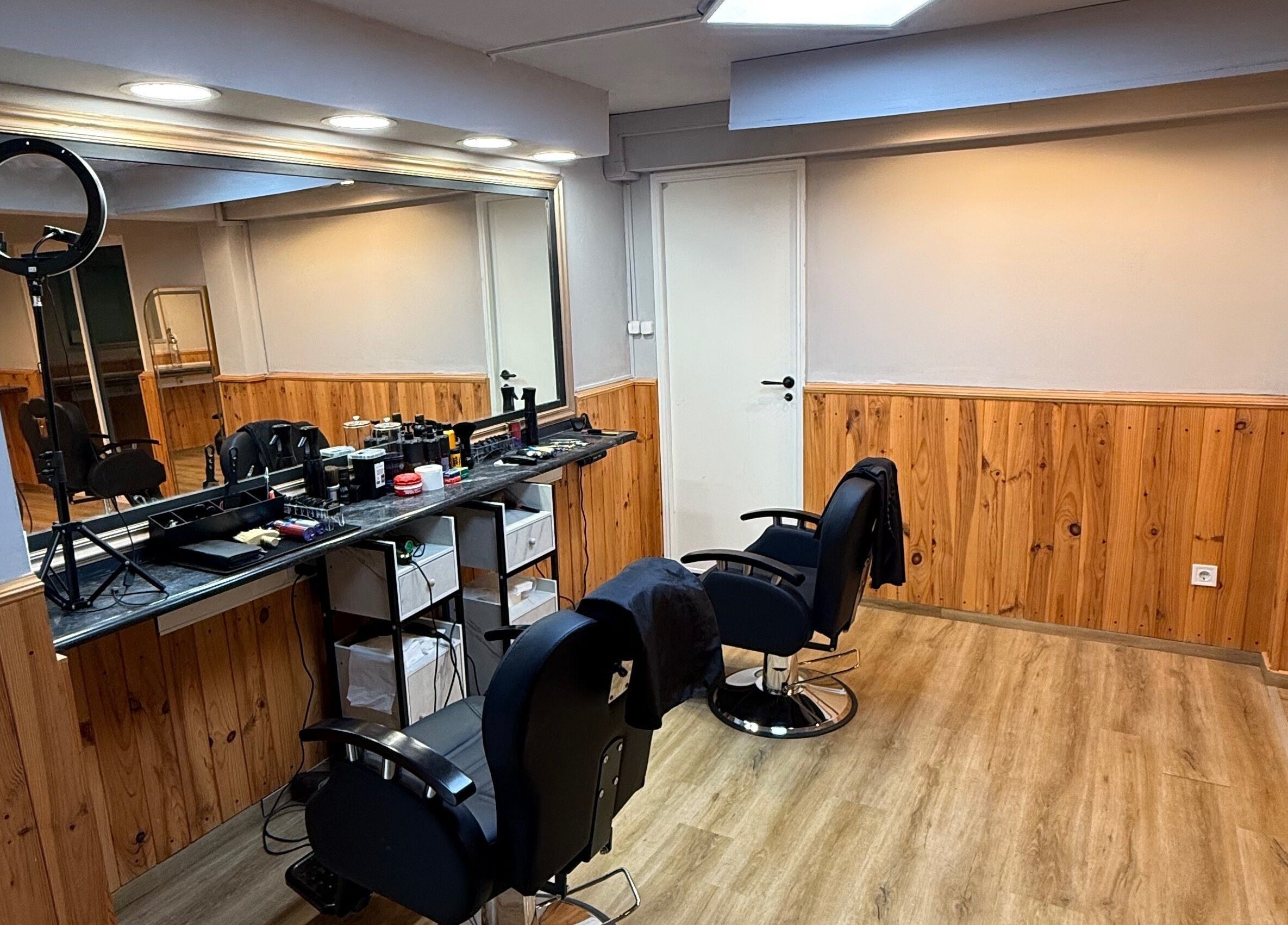 Interior do salão Connect cut Barbers, em Lisboa, PT, com cadeiras e espelhos elegantes.