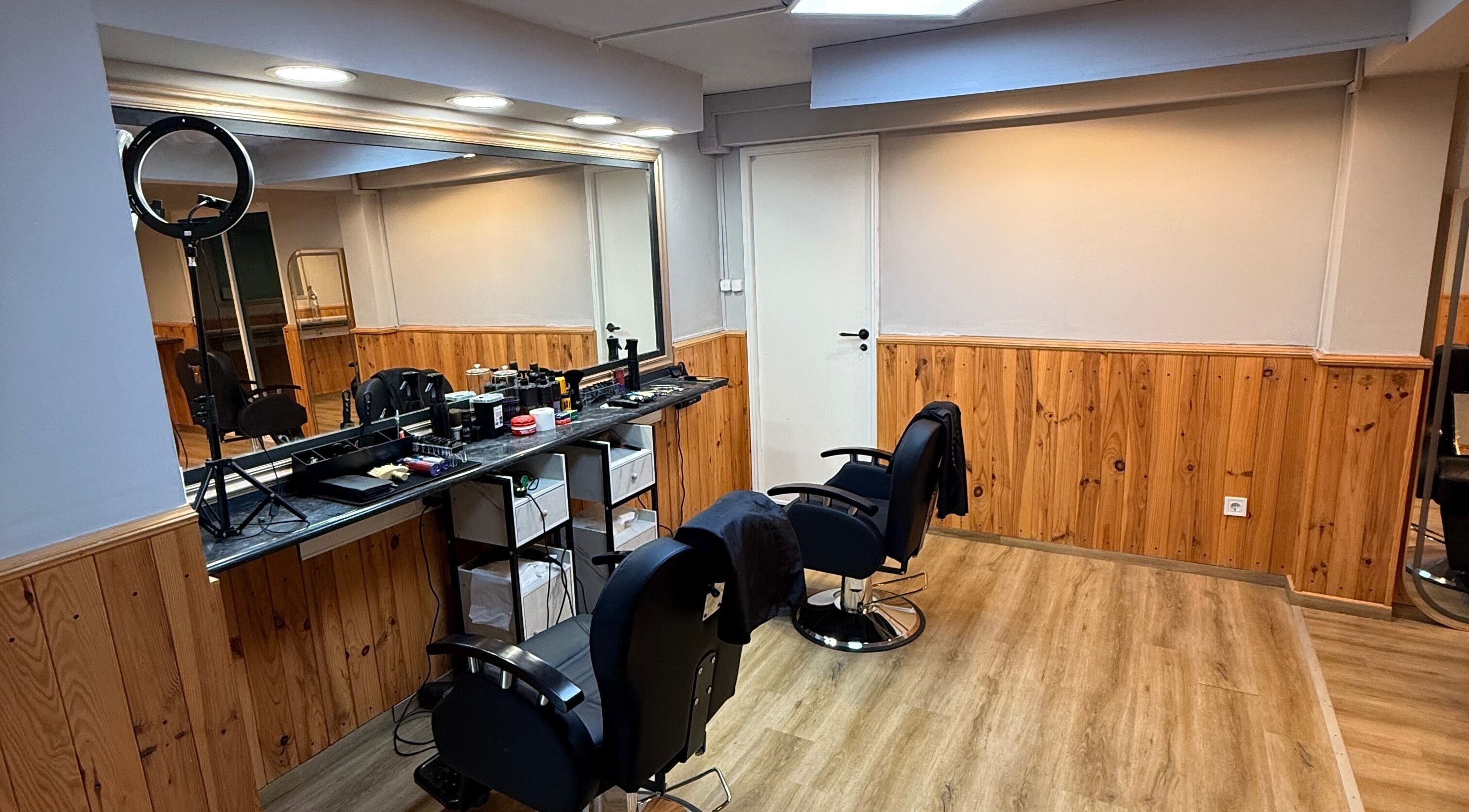 Interior do salão Connect cut Barbers, em Lisboa, PT, com cadeiras e espelhos elegantes.