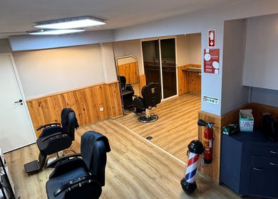 Interior moderno do Connect cut Barbers em Lisboa, PT, com cadeiras elegantes e decoração em madeira.