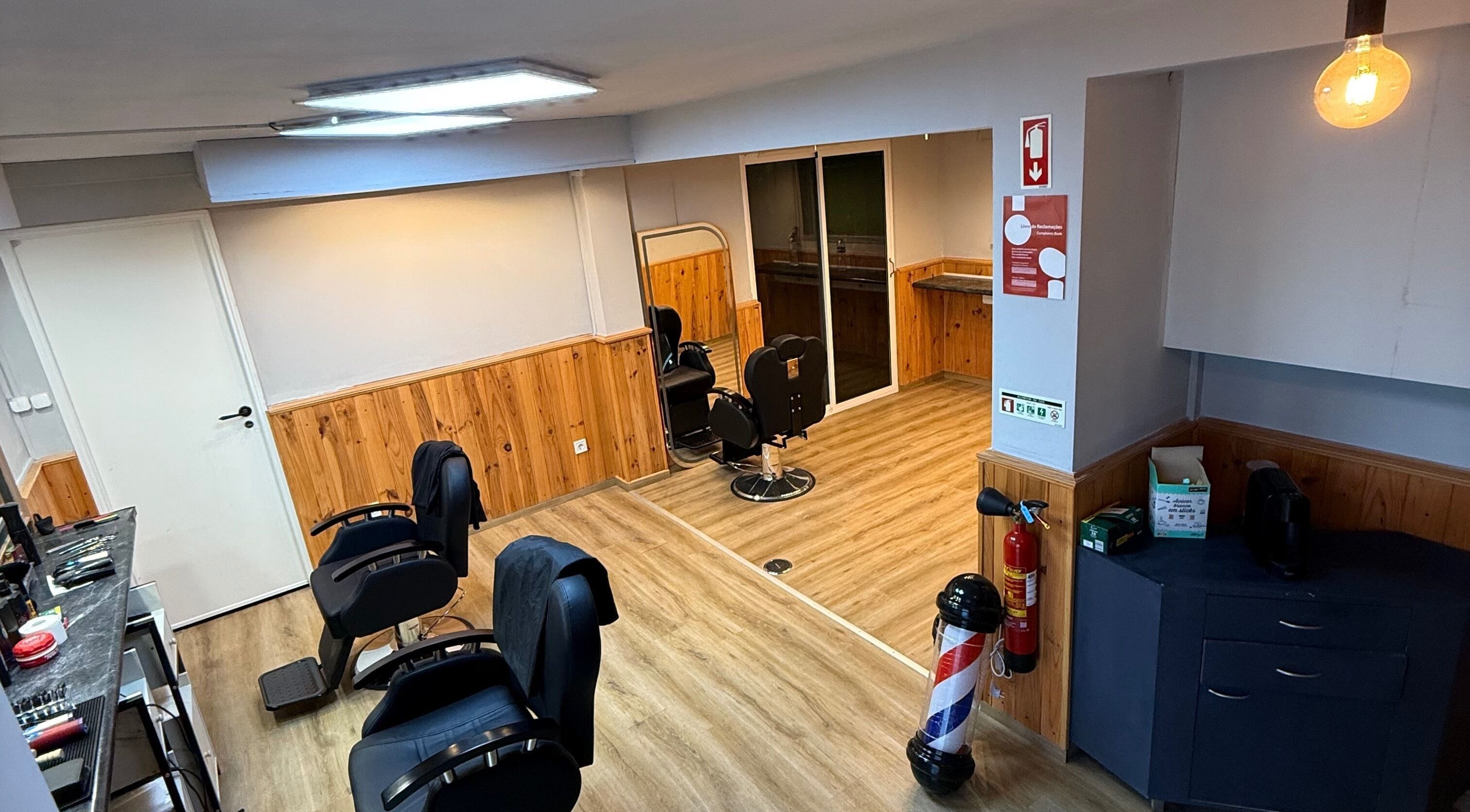 Interior moderno do Connect cut Barbers em Lisboa, PT, com cadeiras elegantes e decoração em madeira.