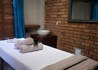 Cozy massage room at Getnailed, Randburg, Gauteng, ZA with brick walls and plush towels.