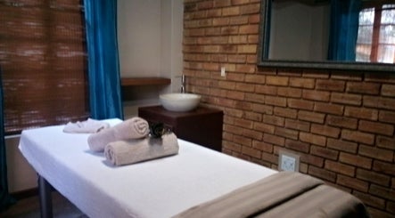 Cozy massage room at Getnailed, Randburg, Gauteng, ZA with brick walls and plush towels.