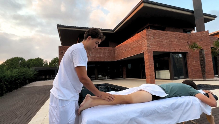 Terapista en Kirozurera Viladecans, Catalunya, ES da masaje al aire libre junto a una piscina.
