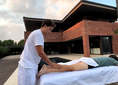 Terapista en Kirozurera Viladecans, Catalunya, ES da masaje al aire libre junto a una piscina.