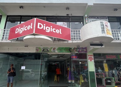 Entrance to Ariacrylics in Arima, Arima Borough Corporation, TT, featuring vibrant storefronts.