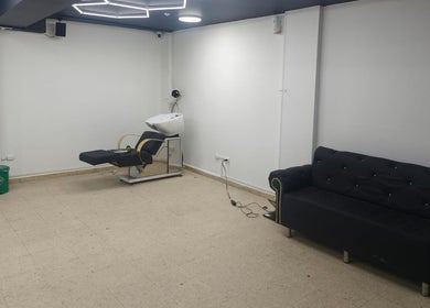 Sala de estética en PEAKY SHADES Bogotá, Bogotá, CO, con sillón negro y silla de lavado.