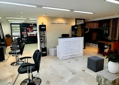 Interior moderno de Sevastian Hair Studio Vip en Quito, Pichincha, EC con sillas de estilistas y mostrador blanco.