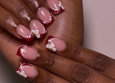 Nail art floral sophistiqué à Clawsy.nail, Noisy-le-sec, Île-de-France, FR. Design rouge et blanc élégant.