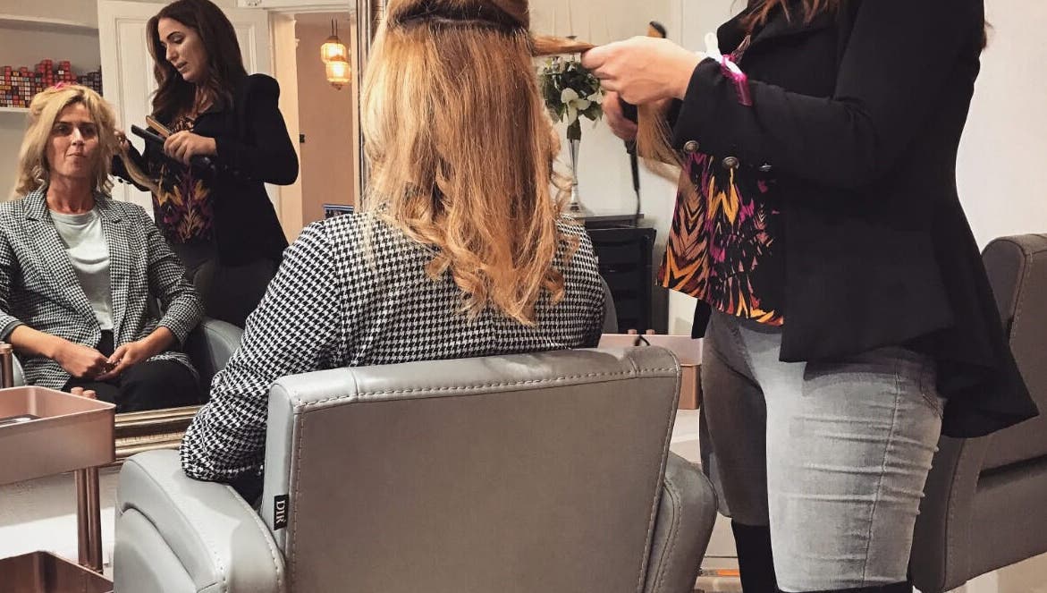 Hairstylist at The Hideaway in Tickhill, England, creates elegant look for client in chic salon setting.