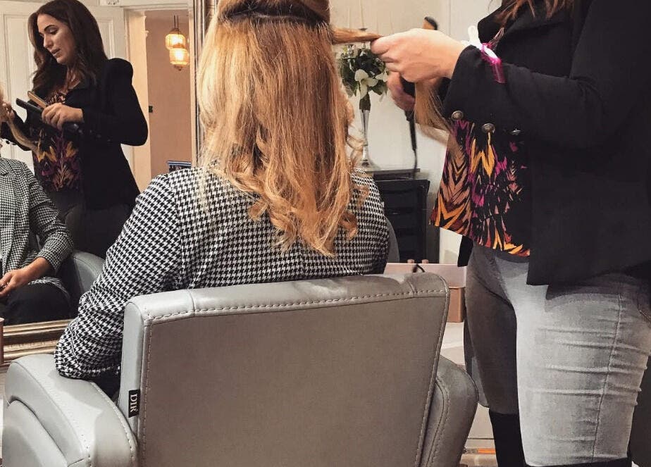 Hairstylist at The Hideaway in Tickhill, England, creates elegant look for client in chic salon setting.