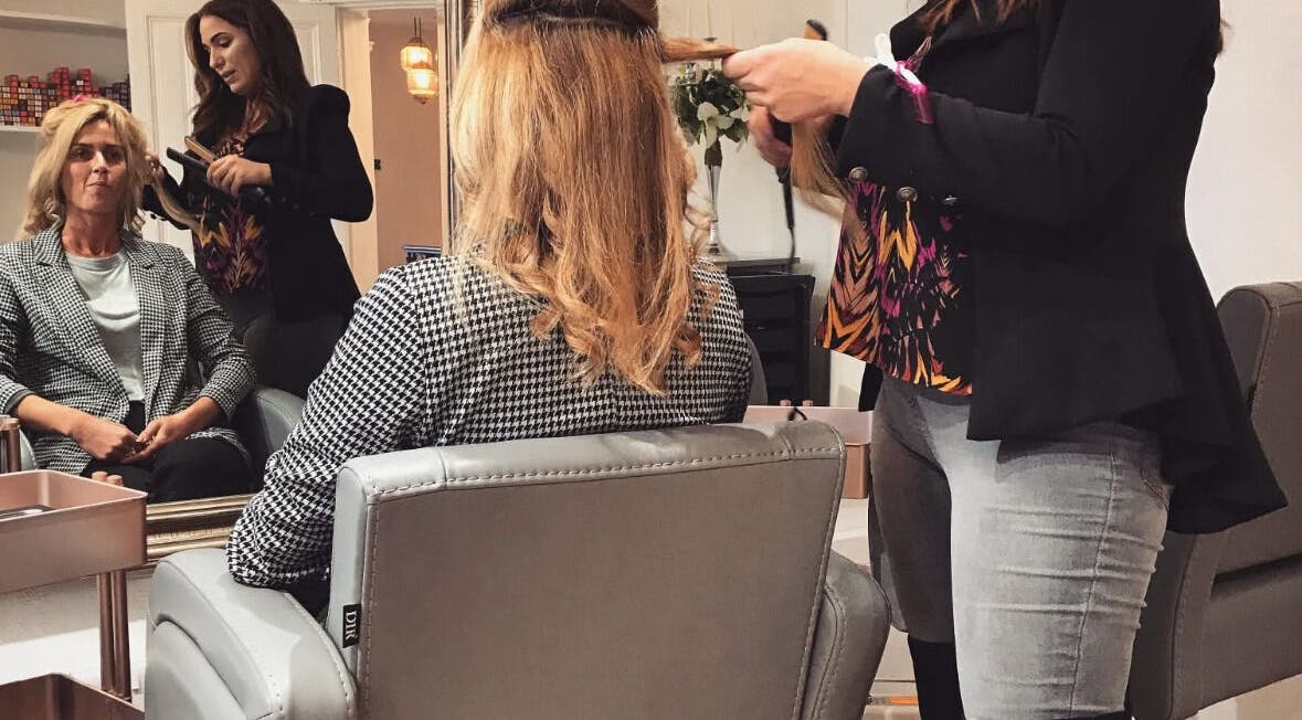 Hairstylist at The Hideaway in Tickhill, England, creates elegant look for client in chic salon setting.