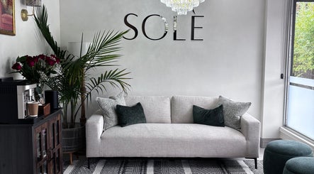 Sleek sofa and decor at Solé Beauty Lounge in London, Ontario, CA offers an inviting ambiance for relaxation.