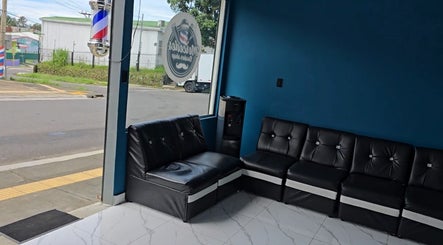 Modern waiting area at Mercedes Barber Shop in Barva, Heredia, CR with stylish seating and decor.