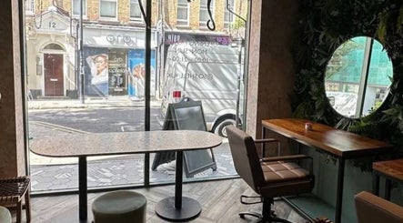 Relaxing interior of Na.Ko Hair London, featuring stylish furniture and green accents in London, England, GB.
