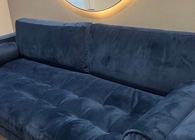 Luxurious navy velvet sofa at Na.Ko Hair London, enhancing elegance in London, England, GB.