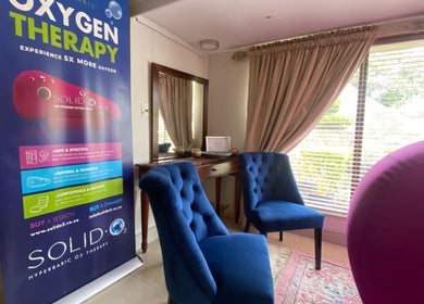 Relaxing lounge at Helderberg Oxygen Therapy in Cape Town, Western Cape, ZA with blue chairs and therapy poster.
