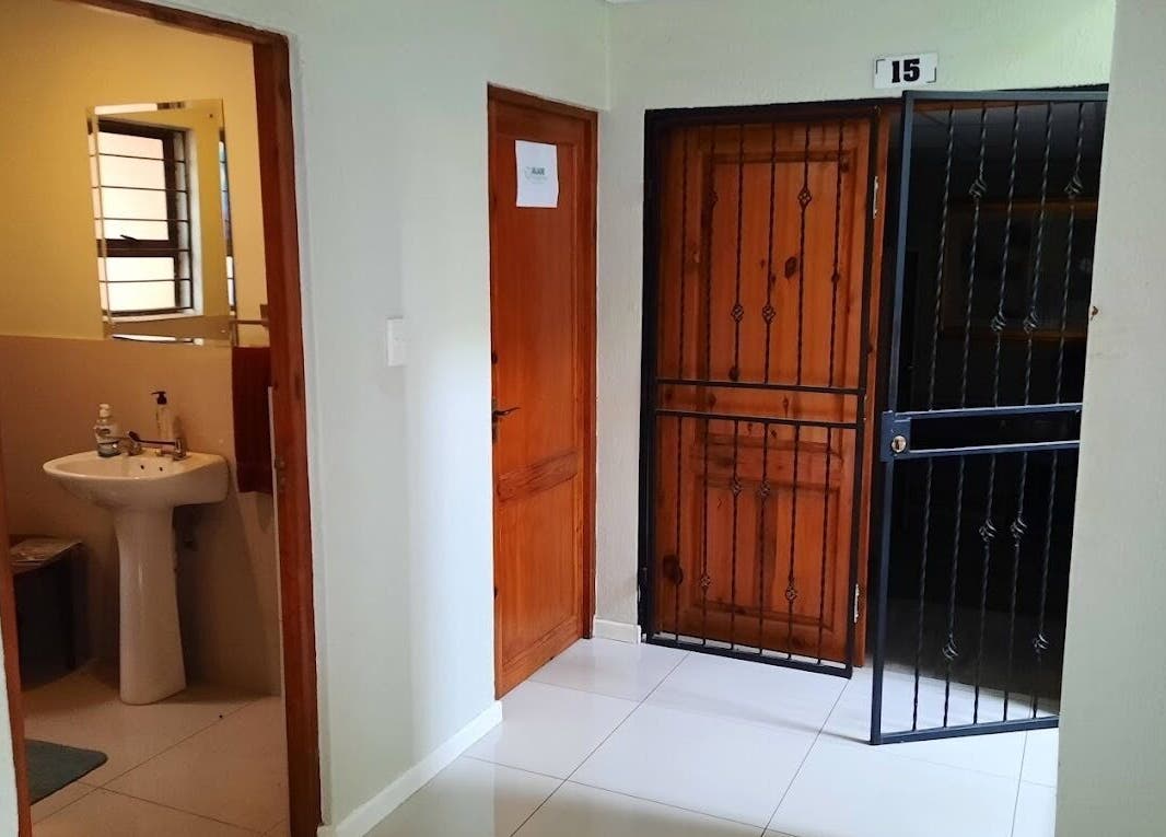 Entrance hallway at Brilliz Salon, Johannesburg, Gauteng, ZA with door to modern bathroom.