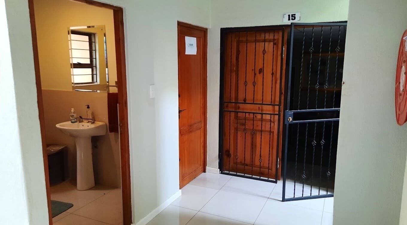 Entrance hallway at Brilliz Salon, Johannesburg, Gauteng, ZA with door to modern bathroom.