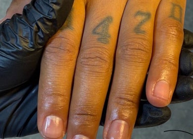 Nahaufnahme einer manikürten Hand mit Tattoos bei LUMINA Beauty Boutique, Schaan, CH.