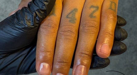 Nahaufnahme einer manikürten Hand mit Tattoos bei LUMINA Beauty Boutique, Schaan, CH.