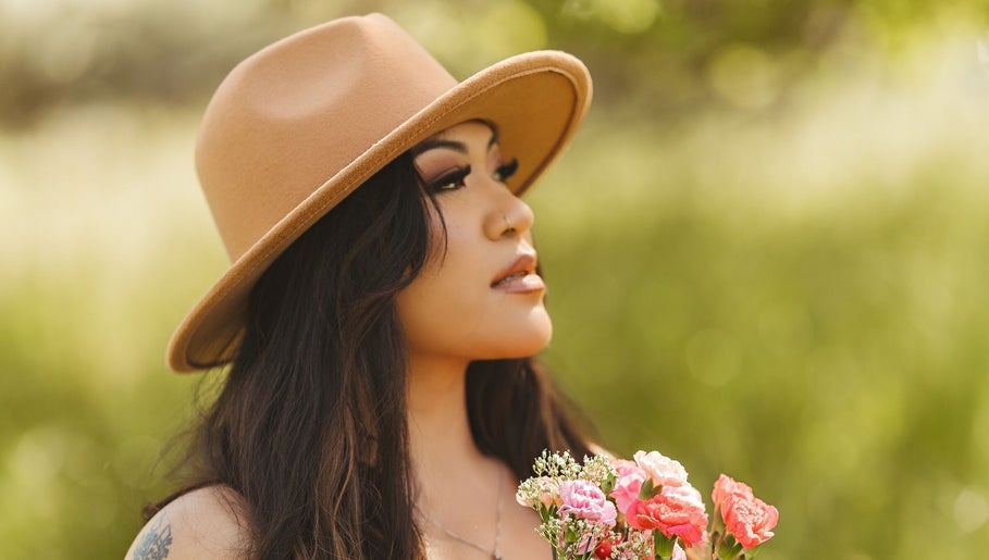 Person in hat with flowers at Oak Soul Collective, Oakland, California, US.