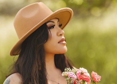 Person in hat with flowers at Oak Soul Collective, Oakland, California, US.