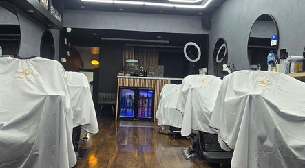 Interior da Vaguinho Barber em Dublin, County Dublin, IE, com cadeiras de corte e espelhos iluminados.