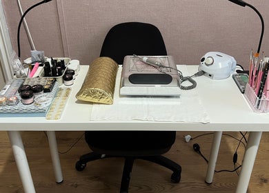 Professional nail studio setup at GLAMMY, London, England, GB, featuring tools and products on a tidy table.
