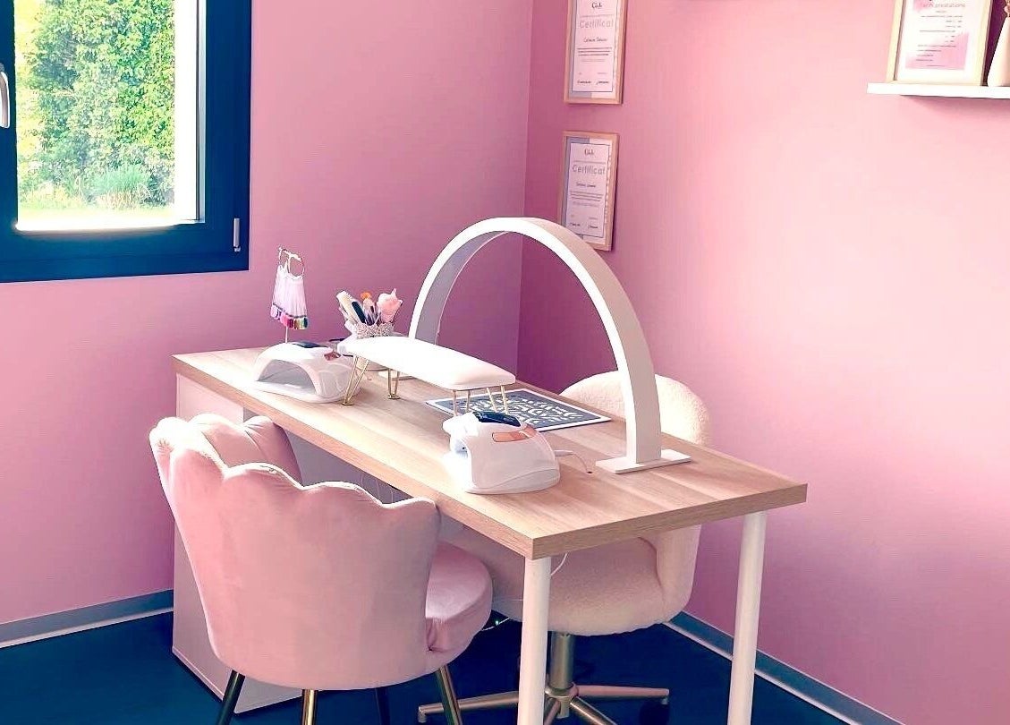 Espace de manucure élégant à La Beauté Rosée, Hirsingue, Grand Est, FR, avec chaise rose et lampes professionnelles.