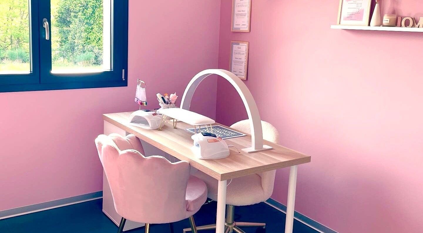 Espace de manucure élégant à La Beauté Rosée, Hirsingue, Grand Est, FR, avec chaise rose et lampes professionnelles.